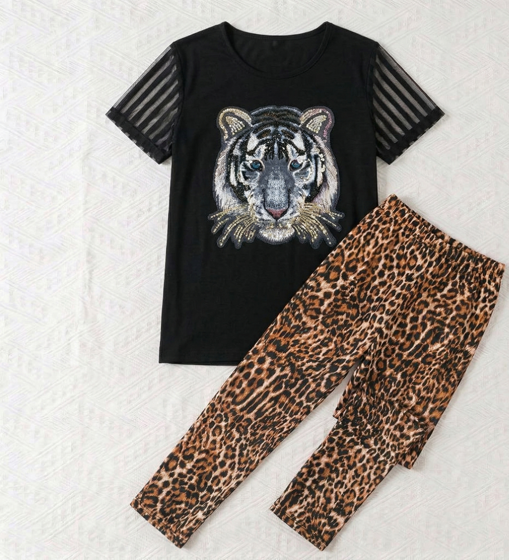 Black t-shirt with tiger design and leopard print pants on a textured white background