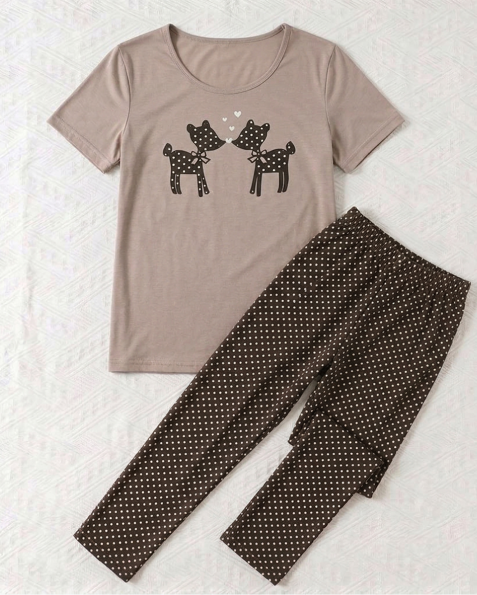 T-shirt with deer design and polka dot pants on a textured white background